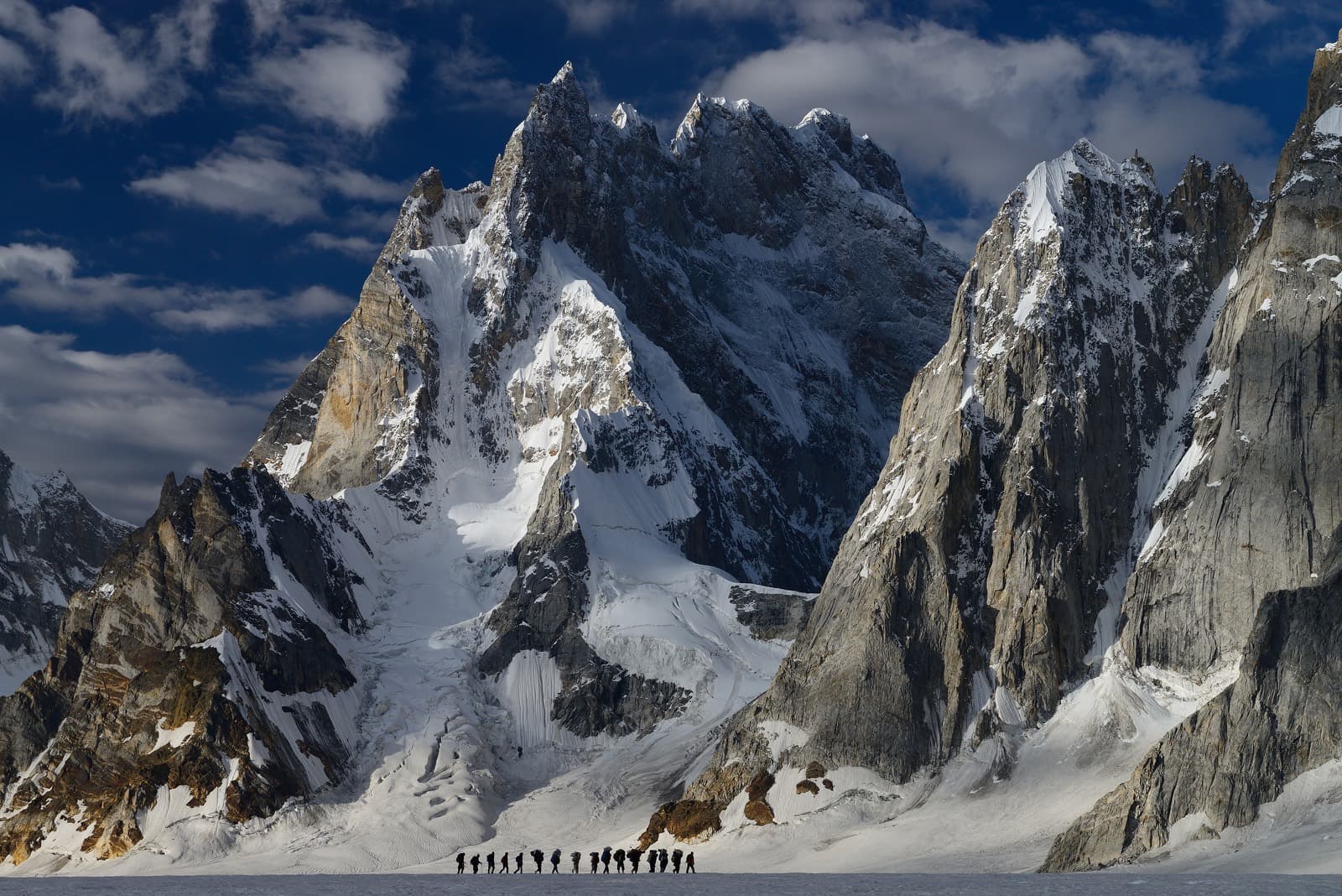 Porters and trekkers crossing the glacier in single file
